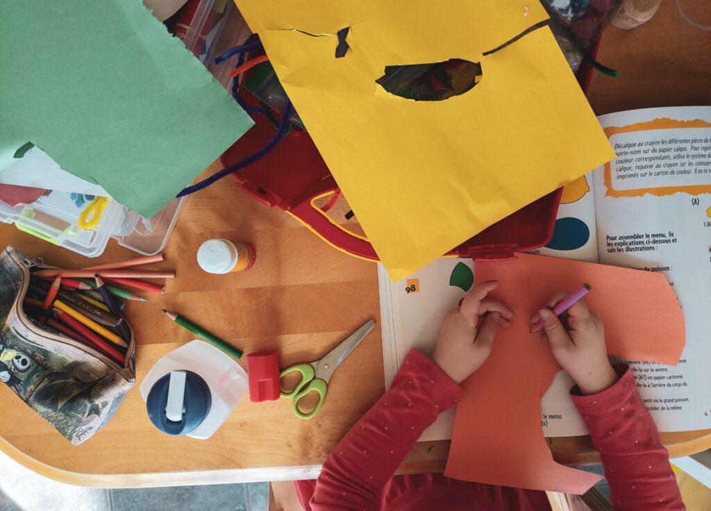 A person is making paper crafts at the table.