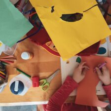 A person is making paper crafts at the table.