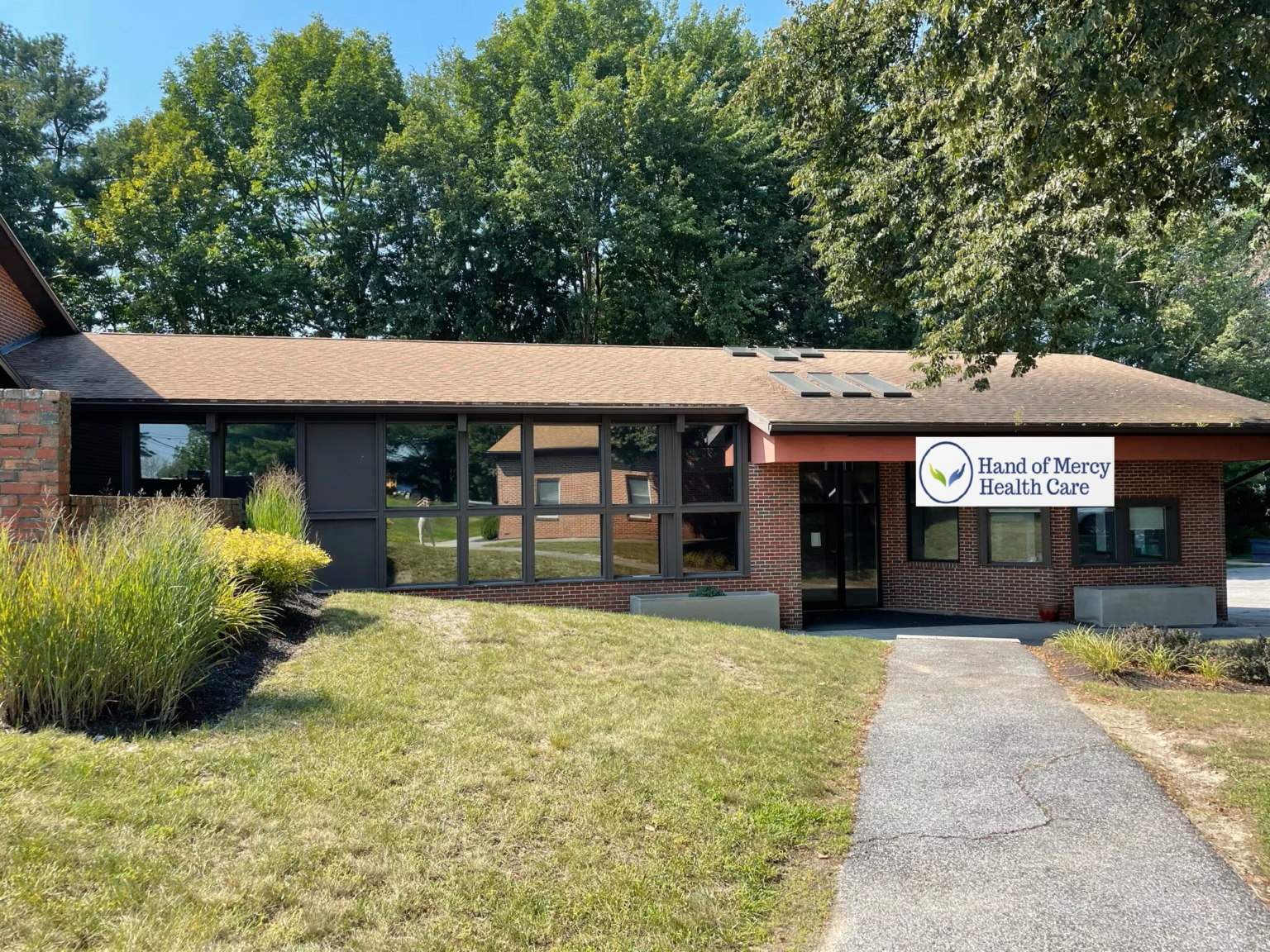 A building with grass and trees in the background.